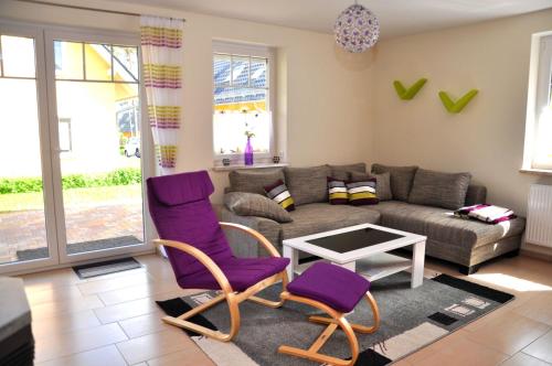 ein Wohnzimmer mit lila Stühlen und einem Sofa in der Unterkunft Ferienwohnungen Appartements - Ferienhaus Müritzwelle in Marienfelde