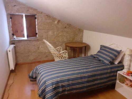 una camera con un letto con una coperta a righe blu e bianche di Casas do Minério a Guarda