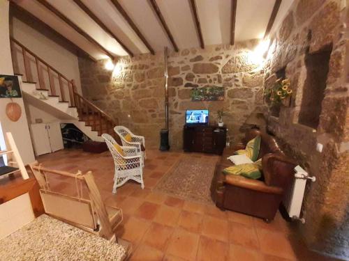 a living room with a couch and chairs and a tv at Casas do Minério in Guarda