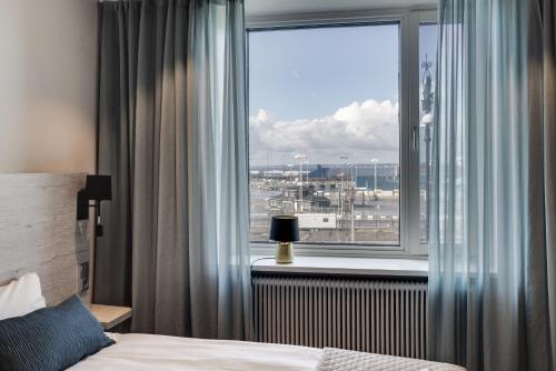 a bedroom with a window with a view of a city at Dream - Luxury Hostel in Helsingborg