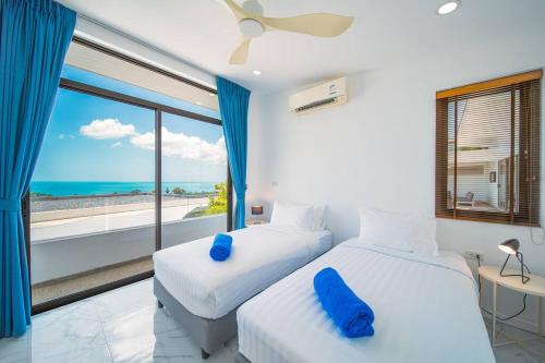 2 camas en una habitación con vistas al océano en Nastha Villa 3 bedrooms en Koh Samui