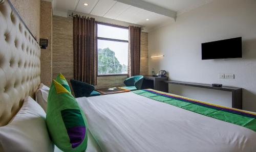 a hotel room with a bed and a television at Treebo Trinetar International in Jammu