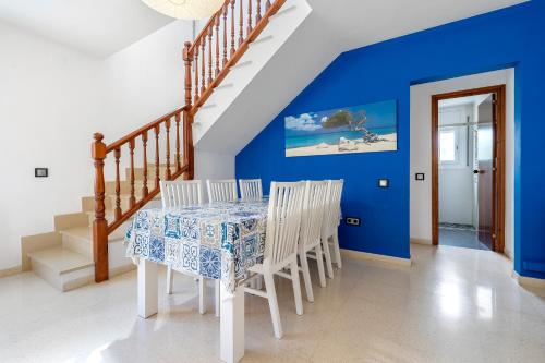 a dining room with a table and chairs and blue walls at Creixell in Creixell