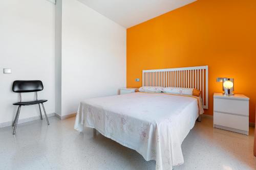 a bedroom with a bed with an orange wall at Creixell in Creixell