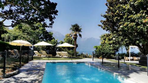 a swimming pool with umbrellas in a yard at Hotel Eden Palace au Lac in Montreux