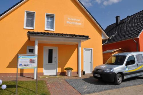 un coche aparcado delante de una casa en Ferienwohnungen Appartements - Ferienhaus Müritzlust, en Marienfelde