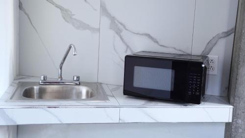 a microwave sitting on a counter next to a sink at Estudio Central London Consulado in Tijuana