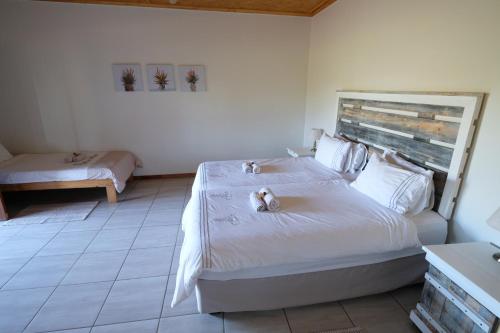 a bedroom with a large white bed with two candles on it at Duwisib Guest Farm in Duwisib