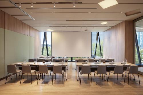 a conference room with tables and chairs and a whiteboard at dusitD2 Samyan Bangkok in Bangkok
