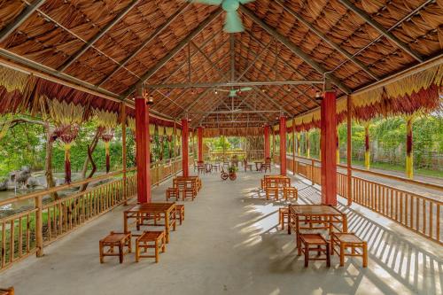 a pavilion with wooden tables and chairs and trees at Hoa Lu Garden Resort in Ninh Binh