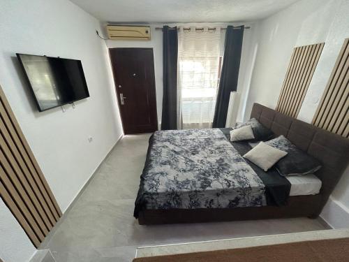 een slaapkamer met een bed en een flatscreen-tv bij Studio apartman Deluxe NAL in Banja Luka