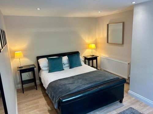 a bedroom with a large bed with blue pillows at The Workshop, Bridge House in Laxey