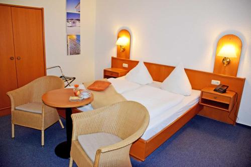 a hotel room with a bed and a table and chairs at Appartementhaus Sellin in Ostseebad Sellin
