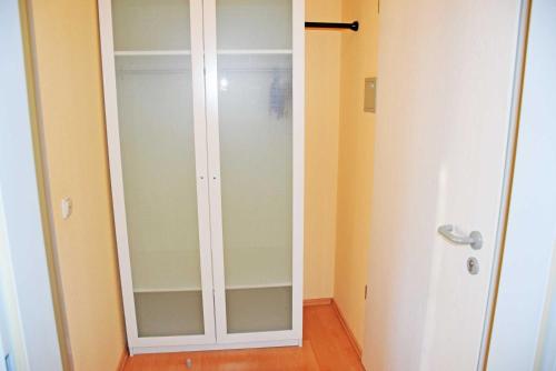 a white closet with a glass door in a room at Appartementhaus Sellin in Ostseebad Sellin