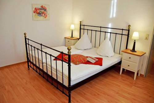 a bedroom with a black bed with white sheets and pillows at Appartementhaus Sellin in Ostseebad Sellin