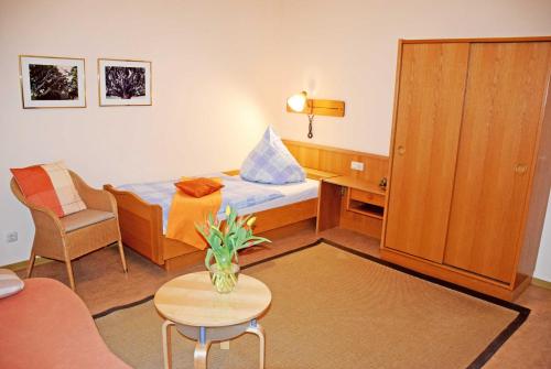 a small room with a bed and a table and a chair at Appartementhaus Sellin in Ostseebad Sellin