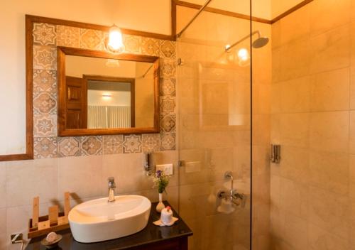 a bathroom with a sink and a shower with a mirror at Sleeping Beauty by Nature Resorts and Stays in Coonoor