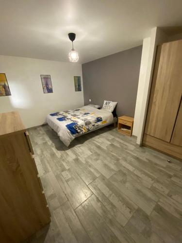 une chambre avec un lit et un parquet dans l'établissement appartement de charme proche de Moissac, à Labastide-du-Temple