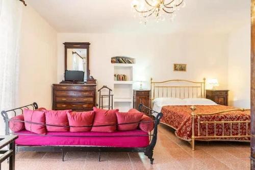 a living room with a pink couch in front of a bed at Casa castello in Rocca Imperiale