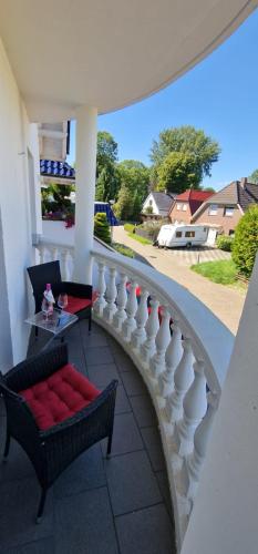 a balcony with a white railing and a table and chairs at Am alten Siel in Wilhelmshaven