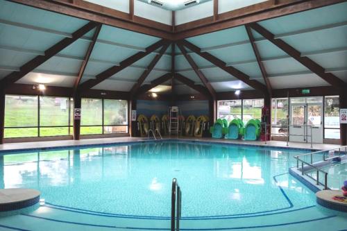 une grande piscine avec un grand plafond dans l'établissement Haven Kent Coast Allhallows 3 bed, à Allhallows