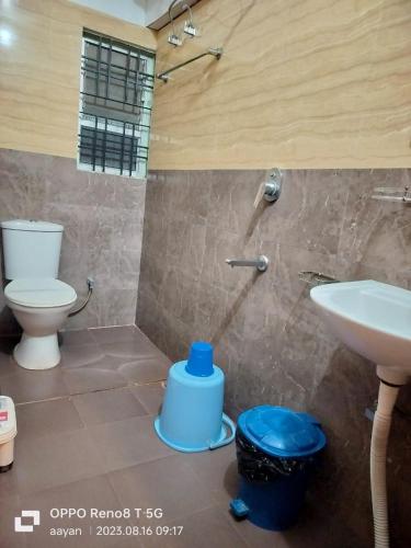 a bathroom with a toilet and a sink at Hotel Jaysha in Guwahati