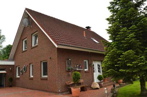 een rood bakstenen huis met een gambrel dak bij Ferienhaus Nikki 35528 in Uplengen