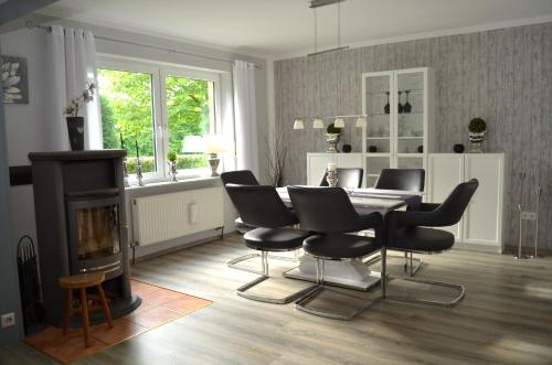 a living room with a table and chairs and a fireplace at Ferienhaus Nikki 35528 in Uplengen