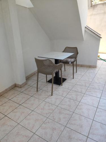 a table and chairs sitting on a tiled floor at Apartments Katica in Metajna