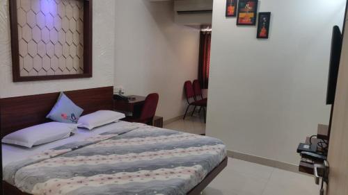 Una cama o camas en una habitación de Hotel Sony Palace, Kolhapur
