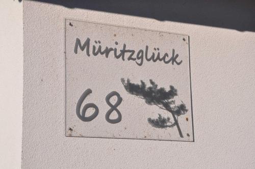 a sign on a wall with the number of a plant at "Ferienwohnungen Appartements - Ferienhaus Müritzglück" in Marienfelde
