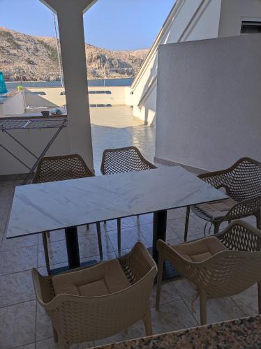 a table and chairs with a view of the water at Apartments Katica in Metajna