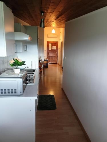 a kitchen with a white refrigerator and a hallway at Tenuta PARAVANO in Povoletto