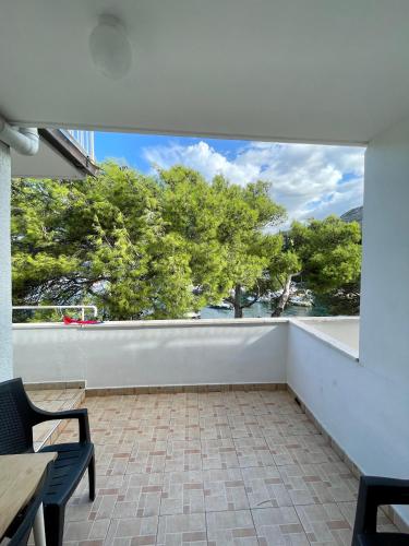 a balcony with a table and chairs and trees at Apartments Boras in Cavtat