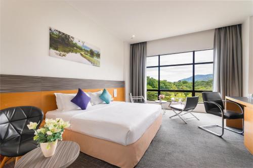 a hotel room with a bed and a desk and chairs at Flemington Hotel in Taiping