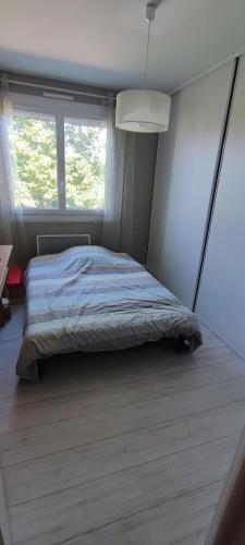1 dormitorio con cama y ventana grande en Maison d'hôtes chez Thibaut, en Pougues-les-Eaux