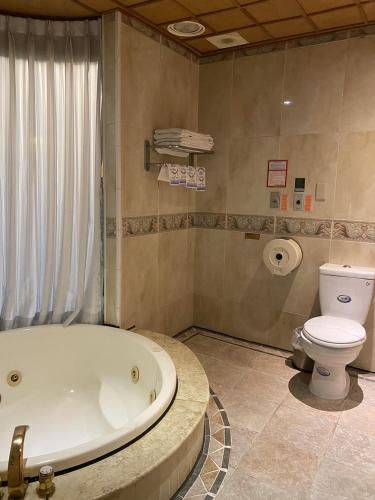 a bathroom with a bath tub and a toilet at I Live Motel in Kaohsiung