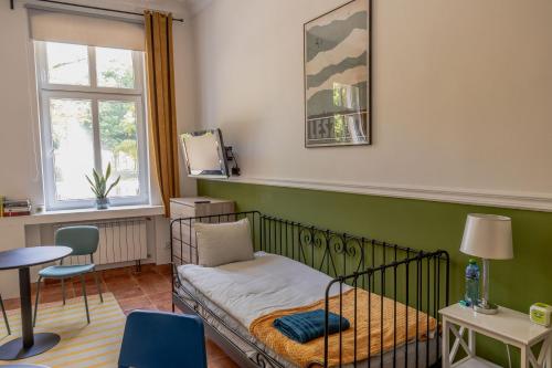a bedroom with a bed and a table and a window at Atelier Hostel in Leszno