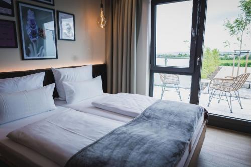 a bedroom with a bed with a view of a patio at Weinzuhause Hotel-Restaurant-Vinothek in Mommenheim
