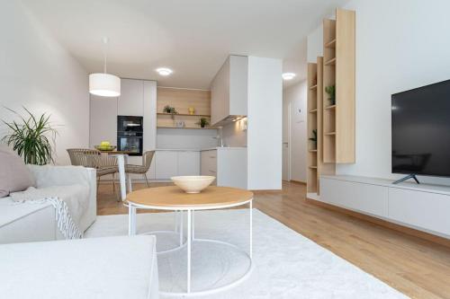 Una sala de estar con un sofá blanco y una mesa. en Apartmán Al-Garden s private garage parking free, 5 min pešo do centra, en Košice