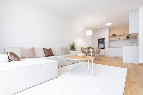 Una sala de estar blanca con un sofá blanco y una mesa. en Apartmán Al-Garden s private garage parking free, 5 min pešo do centra, en Košice