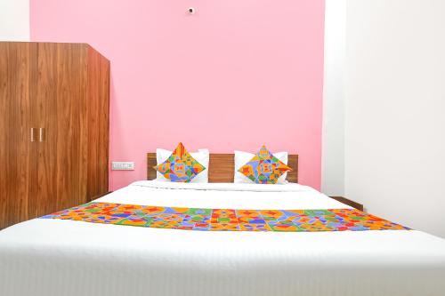 a bedroom with a large bed with a colorful comforter at FabExpress Golden Epoch in Indore