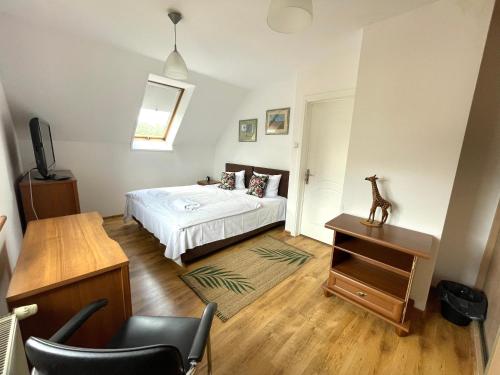 a bedroom with a bed and a table and a chair at Wynajem Pokoi Villa Kofeina in Gdańsk
