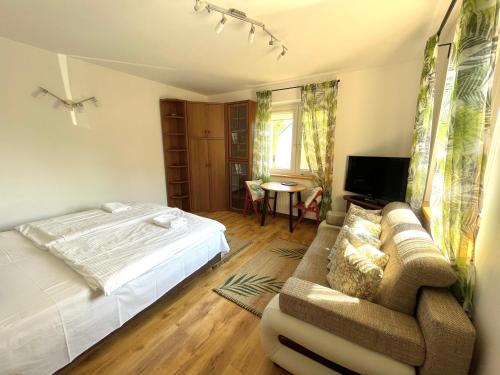 a bedroom with a bed and a couch and a table at Wynajem Pokoi Villa Kofeina in Gdańsk