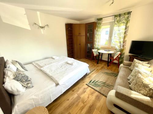 a bedroom with a white bed and a couch at Wynajem Pokoi Villa Kofeina in Gdańsk