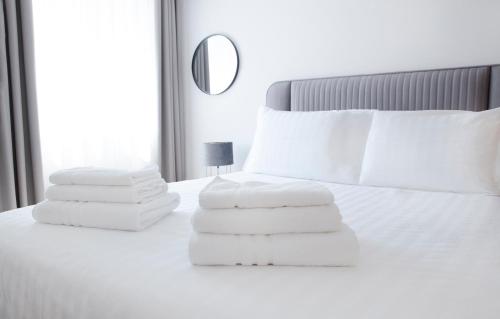 a pile of towels sitting on top of a bed at Nova City Apartments in Varna City