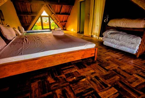 una camera da letto con un letto di legno e una finestra di Oceanis Park Andakana a Andakana