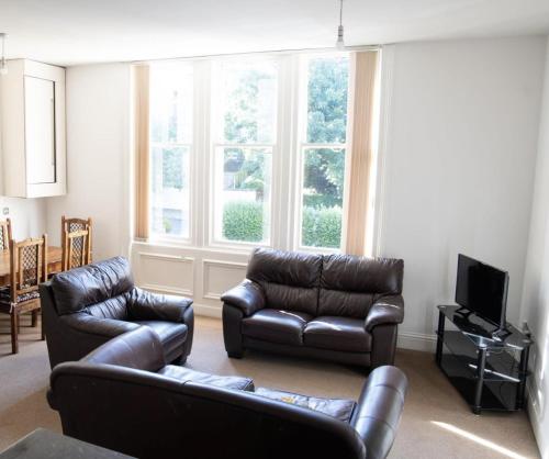 a living room with two leather couches and a television at Thornhill Apartment in Sunderland