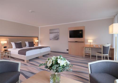 um quarto de hotel com uma cama e uma sala de estar em Seehotel Grossherzog von Mecklenburg em Boltenhagen