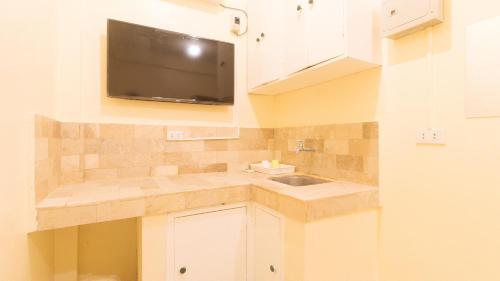 a kitchen with a sink and a tv on the wall at RedDoorz at V-Cloud Hills near De La Salle Dasmarinas Cavite in Dasmariñas